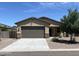 Charming single-story home featuring a two-car garage, well-maintained landscaping, and stone accents at 7218 E Grouse Ct, San Tan Valley, AZ 85143