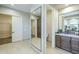 Bright bathroom with tile floor, cabinet with sink, large mirror and access to a closet at 7438 E Visao Dr, Scottsdale, AZ 85266