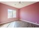 Bedroom with pink walls and wood-look tile flooring features a ceiling fan and a bright window at 7438 E Visao Dr, Scottsdale, AZ 85266