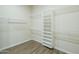 Empty closet with built-in shelving and wood-look tile floors offers ample storage at 7438 E Visao Dr, Scottsdale, AZ 85266