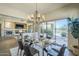 Stylish dining room offers a glass table, contemporary chandelier, and a view to the backyard at 7438 E Visao Dr, Scottsdale, AZ 85266