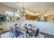 Elegant dining room boasts a glass table, modern chandelier, and open access to the kitchen at 7438 E Visao Dr, Scottsdale, AZ 85266