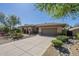 Front exterior with desert landscaping, mature trees and large paver driveway at 7438 E Visao Dr, Scottsdale, AZ 85266