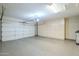 Clean and spacious garage featuring epoxy floors, storage cabinets, and garage door at 7438 E Visao Dr, Scottsdale, AZ 85266
