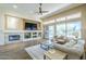 Cozy living room featuring a fireplace, built-in shelving, and a sliding glass door at 7438 E Visao Dr, Scottsdale, AZ 85266