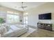 The bright main bedroom features wood-look tile flooring, a ceiling fan, and a large window at 7438 E Visao Dr, Scottsdale, AZ 85266