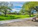Scenic community park with lush green grass, mature trees, and walking paths at 7438 E Visao Dr, Scottsdale, AZ 85266