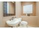 Powder room features a pedestal sink, decorative mirror, and artwork at 7438 E Visao Dr, Scottsdale, AZ 85266