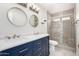Bright bathroom featuring a dual sink vanity, modern lighting, and a glass-enclosed shower at 8157 W Mclellan Rd, Glendale, AZ 85303