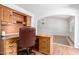 Well-lit home office with traditional wood desk and chair, adjacent to a dining area under an arch at 8157 W Mclellan Rd, Glendale, AZ 85303