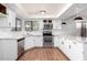 Modern kitchen with white cabinets, stainless steel appliances, and stylish pendant lighting above counters at 8157 W Mclellan Rd, Glendale, AZ 85303