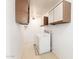 Narrow laundry room with washer, dryer, overhead cabinets, and tile floor at 8157 W Mclellan Rd, Glendale, AZ 85303