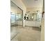 A well-lit bathroom with a double vanity, granite countertop, and tile floor at 9001 W Windsor Ave, Phoenix, AZ 85037