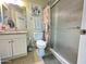Bright bathroom with a single sink vanity, decorative mirror, and a glass-enclosed shower at 9001 W Windsor Ave, Phoenix, AZ 85037