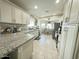 Bright kitchen featuring white cabinets, granite counters, stainless appliances, and tile flooring at 9001 W Windsor Ave, Phoenix, AZ 85037