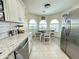 Eat-in kitchen features white cabinets, stainless steel appliances, and a breakfast nook with bright windows at 9001 W Windsor Ave, Phoenix, AZ 85037