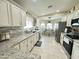 Bright kitchen featuring white cabinets, granite counters, stainless appliances, and tile flooring at 9001 W Windsor Ave, Phoenix, AZ 85037