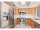 Bright kitchen featuring stainless steel appliances, wood cabinets, and a clean, white tile backsplash at 9151 W Greenway Rd # 212, Peoria, AZ 85381