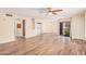 Bright, open-concept living room with wood flooring, ceiling fan, and a view of the balcony at 9151 W Greenway Rd # 212, Peoria, AZ 85381