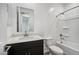 Well-lit bathroom featuring a dark vanity with light countertop and shower-tub combo at 9533 W Luxton Ln, Tolleson, AZ 85353