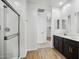 Bathroom with dual sinks, dark wood cabinets, shower stall, and modern fixtures at 9533 W Luxton Ln, Tolleson, AZ 85353