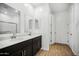 Modern bathroom featuring double sinks, dark wood cabinets, and a large mirror at 9533 W Luxton Ln, Tolleson, AZ 85353