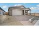 Attractive single-level home with a two-car garage, desert landscaping, and a covered front entryway at 9533 W Luxton Ln, Tolleson, AZ 85353