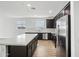 Modern kitchen with a white island, stainless steel appliances, dark cabinets and tiled backsplash at 9533 W Luxton Ln, Tolleson, AZ 85353