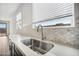 Kitchen sink and countertop feature a stainless sink, and tiled backsplash at 9533 W Luxton Ln, Tolleson, AZ 85353
