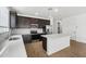 Bright kitchen with dark wood cabinets, stainless appliances, a center island, and tile backsplash at 9533 W Luxton Ln, Tolleson, AZ 85353