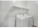 Convenient laundry room equipped with washer, dryer, wire shelves, and vinyl flooring at 9533 W Luxton Ln, Tolleson, AZ 85353