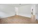 Open-concept living area with wood-look flooring and a view into the kitchen at 9533 W Luxton Ln, Tolleson, AZ 85353