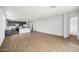 Spacious living area with wood-look flooring leading to a modern kitchen at 9533 W Luxton Ln, Tolleson, AZ 85353