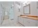Well-lit bathroom featuring a glass-enclosed shower, vanity with wood countertop, and modern fixtures at 9851 N 28Th Way, Phoenix, AZ 85028