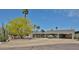 Inviting single-story home showcasing desert landscaping with mature trees and a covered carport at 9851 N 28Th Way, Phoenix, AZ 85028