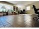 Spacious living room featuring tile flooring, built-in shelves, a desk area, and many indoor plants by the window at 9851 N 28Th Way, Phoenix, AZ 85028