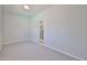 Minimalist room with gray flooring, white brick walls, and a glass door to a brighter space at 9851 N 28Th Way, Phoenix, AZ 85028