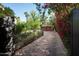 Long driveway lined with blooming flowers leads to a wooden garage door at 1015 W Encanto Blvd, Phoenix, AZ 85007