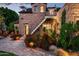Stone home's exterior, featuring a wrought iron stairway, is enhanced by vibrant flowering plants at 1015 W Encanto Blvd, Phoenix, AZ 85007