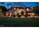 The stone home exterior is beautifully lit with professional lighting, with manicured lawn, and mature landscaping at 1015 W Encanto Blvd, Phoenix, AZ 85007