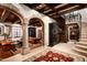 Grand foyer featuring stone archways, wood beam ceilings, decorative rugs, staircase, and stylish furnishings at 1015 W Encanto Blvd, Phoenix, AZ 85007