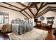 Vaulted bedroom features exposed wood beams, dark hardwood floors, and a cozy seating area with two leather chairs at 1015 W Encanto Blvd, Phoenix, AZ 85007