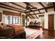 Serene main bedroom with wood beam ceilings, large windows, elegant decor, and a cozy sitting area at 1015 W Encanto Blvd, Phoenix, AZ 85007