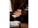 Elegant grand piano in a room with natural light, featuring a matching upholstered bench at 1015 W Encanto Blvd, Phoenix, AZ 85007