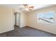 Bedroom with carpet, ceiling fan, natural light from a large window, and white door at 10324 W Sands Dr # 476, Peoria, AZ 85383