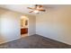 Spacious bedroom featuring neutral walls, carpet, and a ceiling fan with bathroom access through an archway at 10324 W Sands Dr # 476, Peoria, AZ 85383