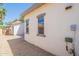 Side yard view of the stucco wall exterior with paver patio and desert landscaping at 10324 W Sands Dr # 476, Peoria, AZ 85383