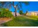 Expansive backyard with lush lawn and mature trees under a twilight sky at 10532 N 79Th St, Scottsdale, AZ 85258