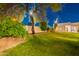 Backyard at night with green lawn, trees, exterior lighting, and the home's facade in the background at 10532 N 79Th St, Scottsdale, AZ 85258