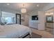 Bright bedroom featuring balcony access, en-suite bathroom, TV, dresser, and neutral tones at 10532 N 79Th St, Scottsdale, AZ 85258